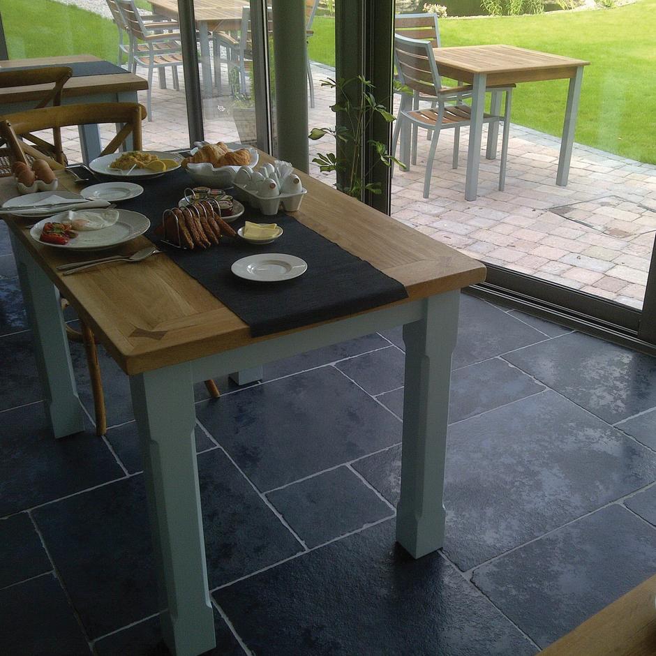 Garden dining patio area with weathered carbon black limestone paving slabs
