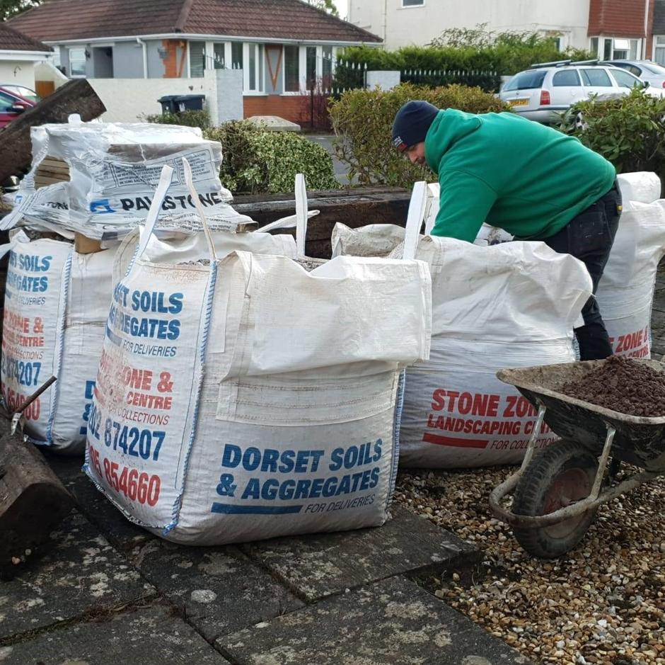landscaper filling jumbo bag with waste