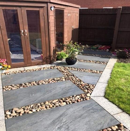 Sienna™ Anthracite Black Porcelain Paving garden with decorative stones and grass