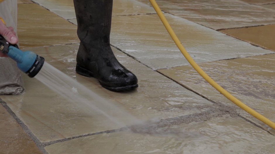 all-weather jointing compound being hosed into garden paving