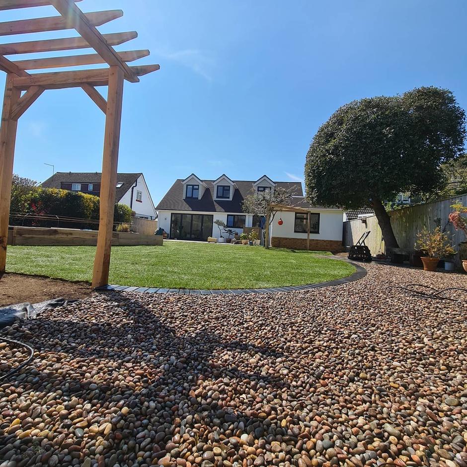 scottish pebbles in large back garden with pergola