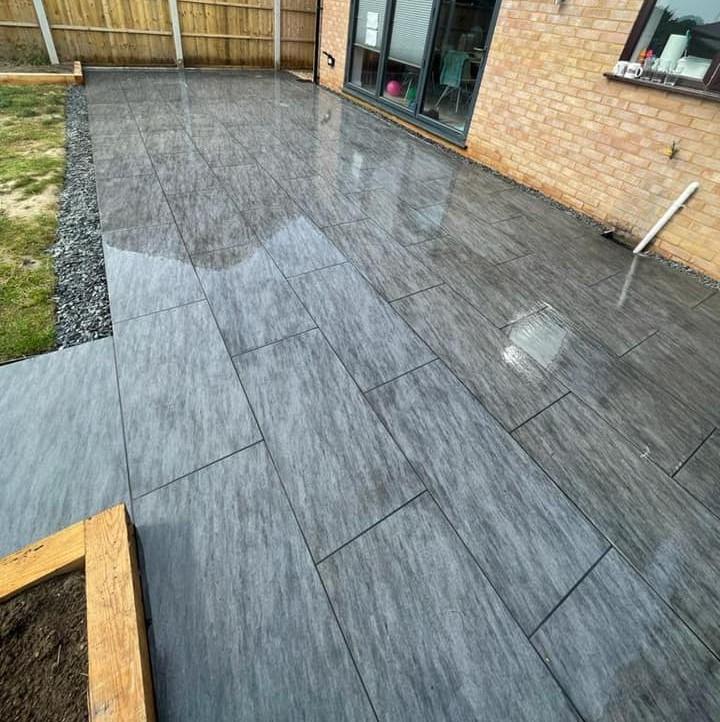 Sienna™ Anthracite Black Porcelain Paving shiny paving slabs in garden
