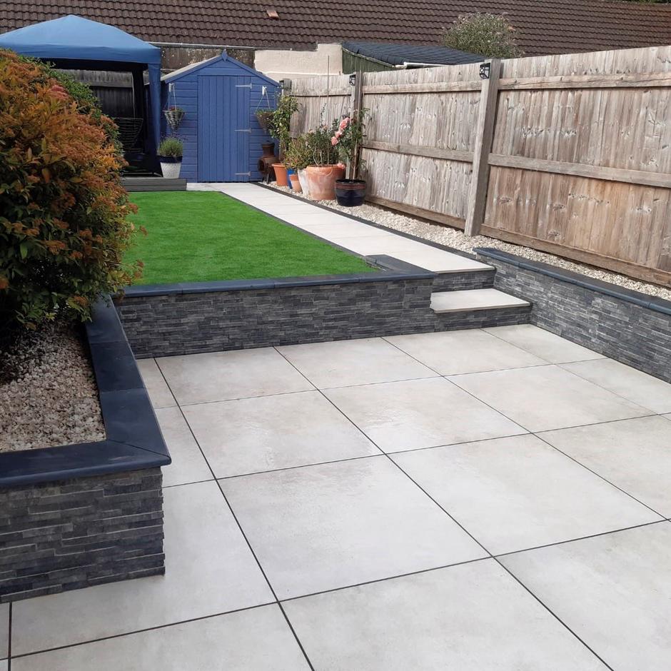 spectrum montego dust grey porcelain paving in garden with cladding