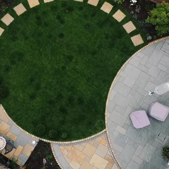 garden patio paving with blue and yellow limestone and grass