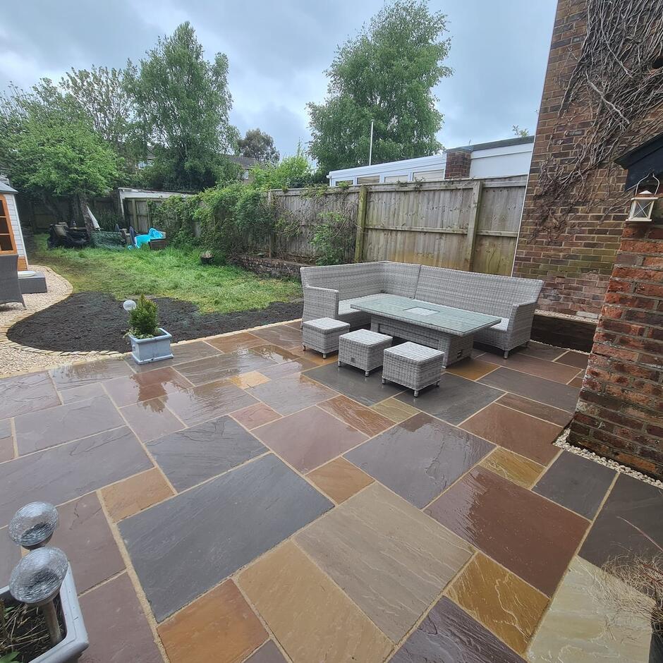 Fernlea Raj Green Sandstone Paving with garden furniture fresh turf and fencing