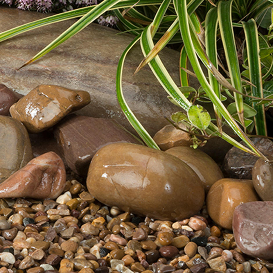 Tweed pebbles and cobbles wet in rockery feature