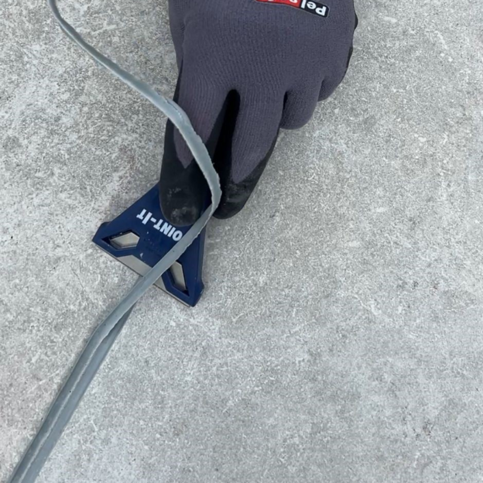 Joint-it grey grout excess being scraped from paving slabs