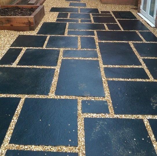 Black paving slabs laid on shingle