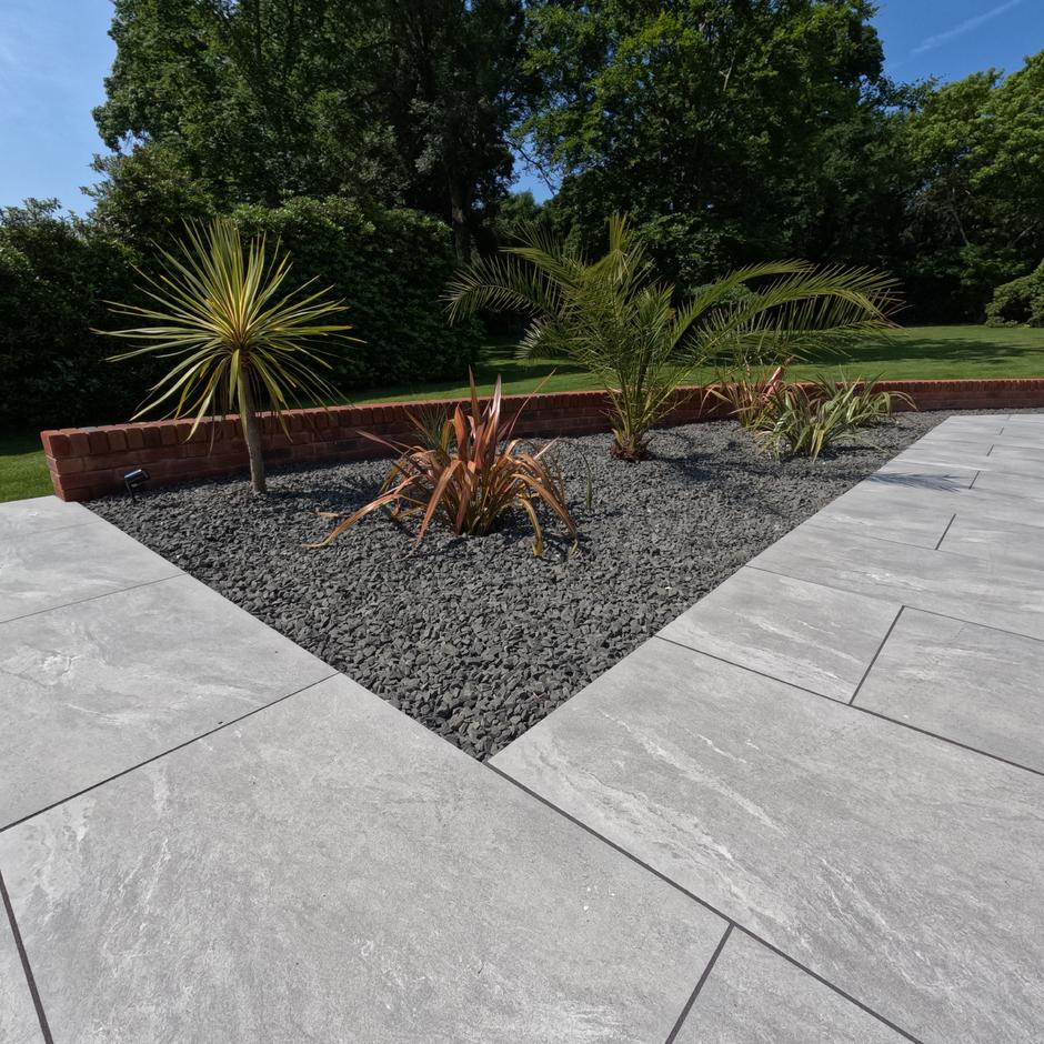 Sienna™ Jupiter Argent Porcelain Paving grey paving tiles with black basalt garden stones