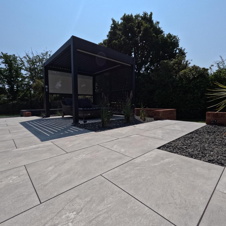 Black Basalt Chippings 20mm; dark grey decorative gardens stones paired with porcelain tiles and pergolas