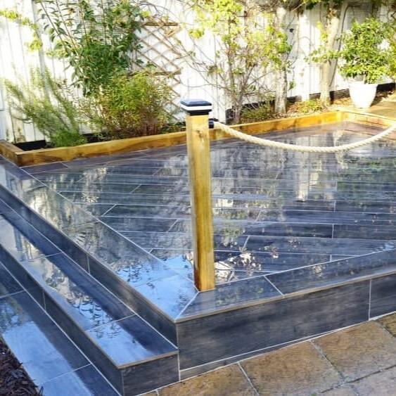 Woodland wood-effect Anthracite Grey Black Porcelain Paving Slab up-close bank garden