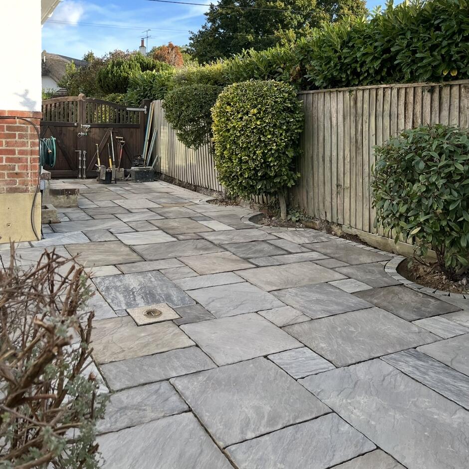 Havana Sandstone Paving (Weathered) back garden with fencing and foliage