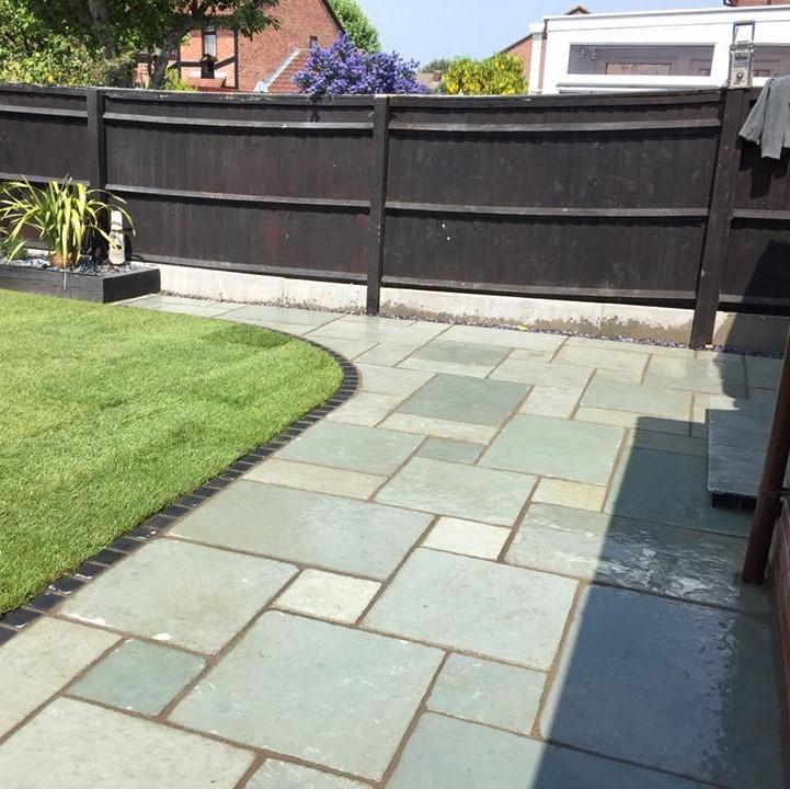 Square edge aqua blue limestone paving with grouting in back garden