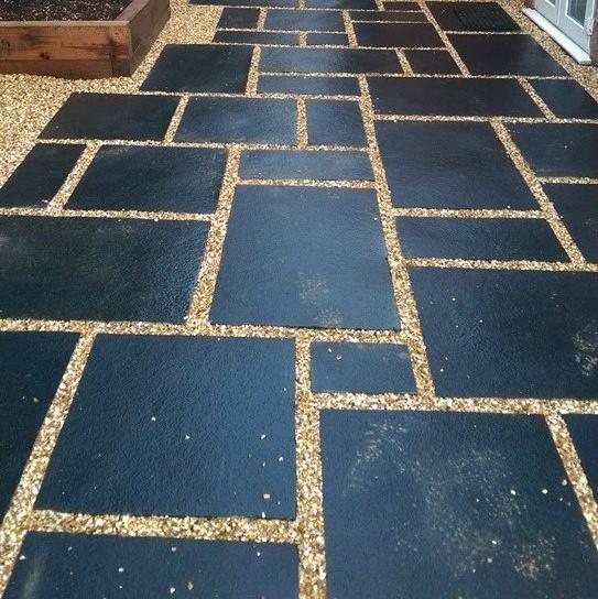 charcoal natural paving slabs laid within shingle