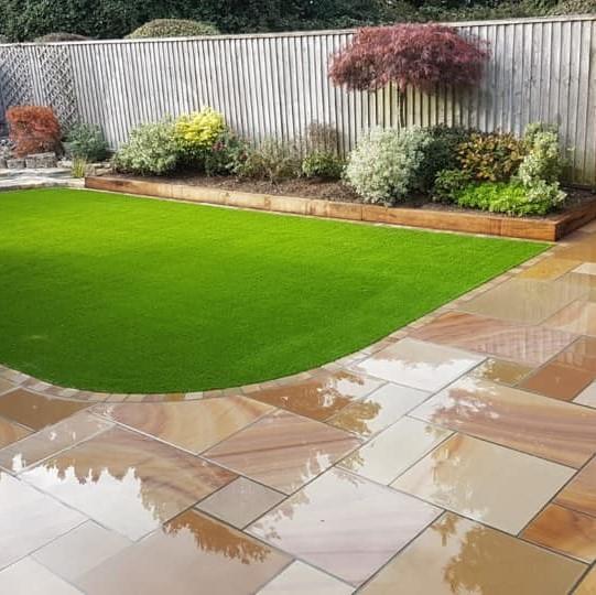 smooth buff paving slabs in garden with grass