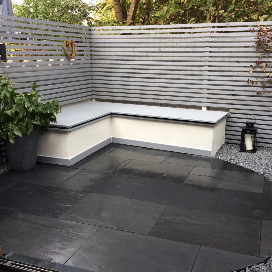 patio with black slate paving with white furniture and fencing